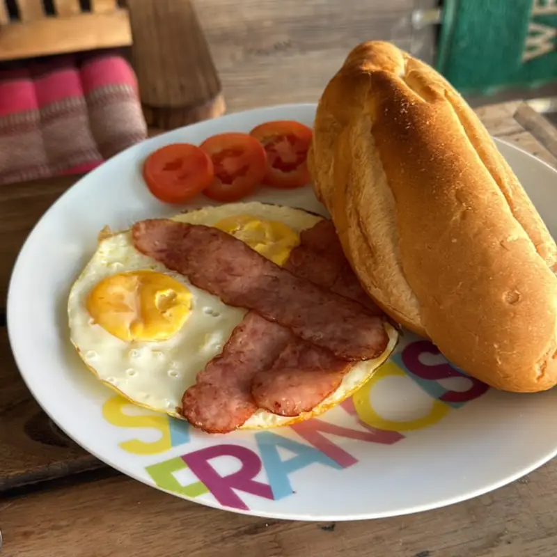 Fried eggs with ham, tomato and warm baguette