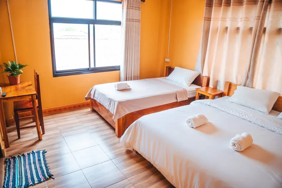 Family room with two beds and a desk at Vang Vieng Sunset Guesthouse