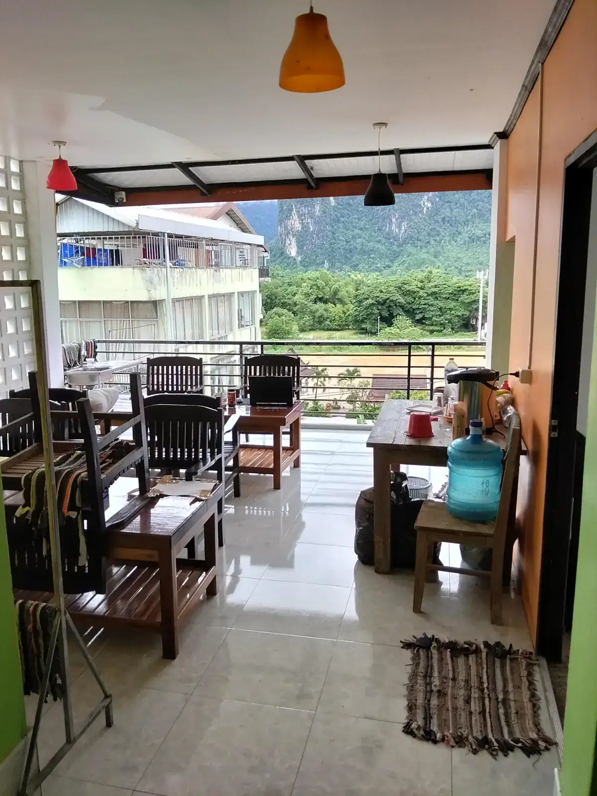 Covered rooftop terrace at Vang Vieng Sunset with seating and views over the Nam Song River and karst mountains